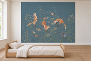 Cerfs & fleurs, motif 1 : trois renards bondissants, oiseaux, lapin et fleurs champêtres sur fond bleu ardoise, posé en papier peint dans une chambre d’enfant lumineuse avec lit bas et linge clair.