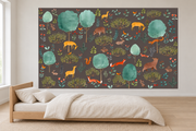 Cerfs & fleurs, motif 7 : cerfs jaunes, ours, renards, lapins et oiseaux parmi de grands arbres turquoise sur fond brun grisé foncé, posé en papier peint dans une chambre d’enfant lumineuse avec lit bas et linge clair.