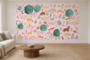 Cerfs & fleurs, motif 8 : cerfs jaunes, ours, renards, lapins et oiseaux parmi de grands arbres turquoise sur fond rose pâle, posé en papier peint dans un salon familial lumineux avec canapé en lin clair.
