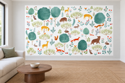 Cerfs & fleurs, motif 9 : cerfs jaunes, ours, renards, lapins et oiseaux parmi de grands arbres turquoise sur fond blanc, posé en papier peint dans un salon familial lumineux avec canapé en lin clair.