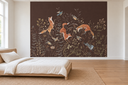 Cerfs & fleurs, motif 10 : trois renards bondissants, oiseaux, lapins gris bleuté et fleurs fines sur fond brun natif, posé en papier peint dans une chambre d’enfant lumineuse avec lit bas et linge clair.