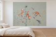 Cerfs & fleurs, motif 11 : trois renards bondissants, oiseaux, lapins gris bleuté et fleurs fines sur fond vert grisé pâle natif, posé en papier peint dans une chambre d’enfant lumineuse avec lit bas et linge clair.