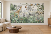 Safari aquarelle, motif 1 : jungle aquarellée gris vert, girafe à gauche, éléphant au centre, zèbre à droite, léopard couché sur une branche et singes en haut, posé en papier peint dans un salon familial lumineux avec canapé en lin clair.