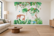 Safari aquarelle, motif 2 : jungle aquarellée verte sur fond blanc, girafe penchée vers son petit, petits animaux dans les branches et papillons, posé en papier peint dans un salon familial lumineux avec canapé en lin clair.