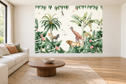 Safari aquarelle, motif 3 : jungle sur fond crème, lion au premier plan, girafe à droite, zèbre sous un palmier à gauche et singe suspendu, posé en papier peint dans un salon familial lumineux avec canapé en lin clair.