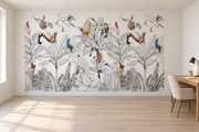 Safari aquarelle, motif 4 : feuillage tropical noir et blanc finement dessiné, lémuriens et petits singes roux, oiseaux rouges et bleus et toucan, posé en papier peint dans un bureau familial clair avec table de travail en bois.