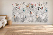 Safari aquarelle, motif 4 : feuillage tropical noir et blanc finement dessiné, lémuriens et petits singes roux, oiseaux rouges et bleus et toucan, posé en papier peint dans une chambre d’enfant lumineuse avec lit bas et linge clair.