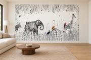 Safari aquarelle, motif 5 : jungle finement dessinée noir et blanc, éléphant à gauche, girafe à droite, zèbre coupé au bord gauche et oiseaux colorés, posé en papier peint dans un salon familial lumineux avec canapé en lin clair.