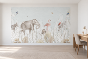 Safari aquarelle, motif 6 : jungle aquarellée très pâle sur fond gris sauge clair, éléphant et tortue, zèbre, flamant rose, petite chouette, girafe et oiseaux, posé en papier peint dans un bureau familial clair avec table de travail en bois.