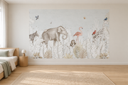 Safari aquarelle, motif 6 : jungle aquarellée très pâle sur fond gris sauge clair, éléphant et tortue, zèbre, flamant rose, petite chouette, girafe et oiseaux, posé en papier peint dans une chambre d’enfant lumineuse avec lit bas et linge clair.